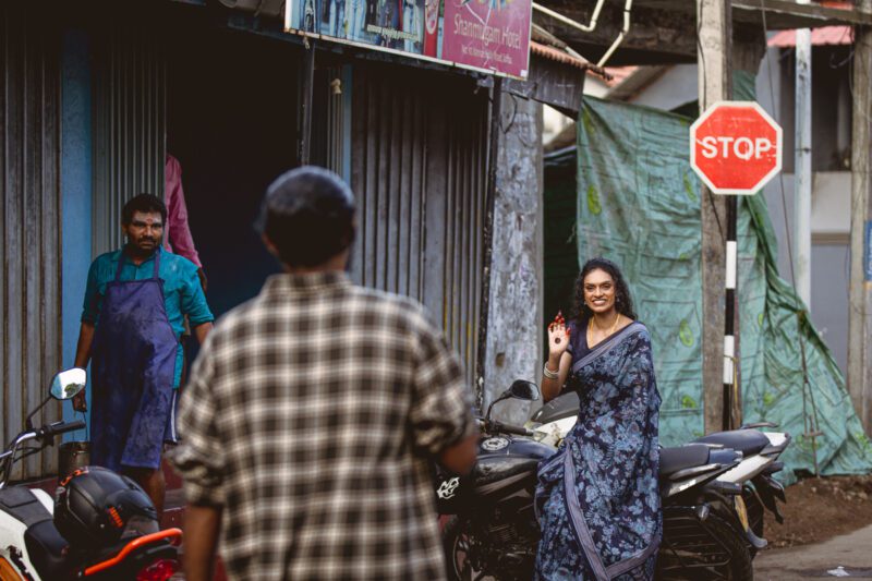 Kobe and Ramya walking through the quiet streets of Jaffna city, surrounded by colonial-style buildings and everyday life. A candid post-wedding moment captured by Banu Photography