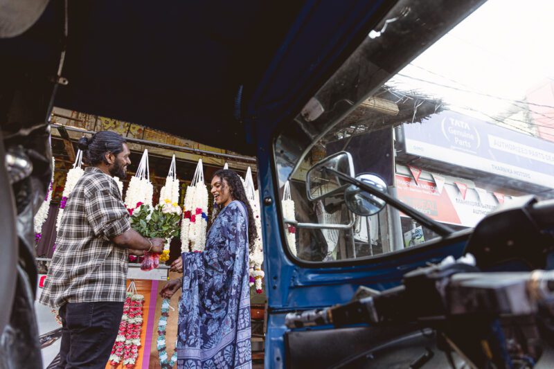 Kobe and Ramya walking through the quiet streets of Jaffna city, surrounded by colonial-style buildings and everyday life. A candid post-wedding moment captured by Banu Photography